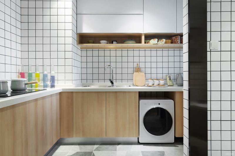 厨房白色正方形墙砖，黑色勾缝。白色台面、原木色的橱柜，灰色拼花地砖。