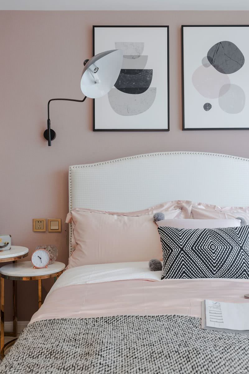 白色背垫与粉色床品，黑白色抱枕与墙上壁灯对应。