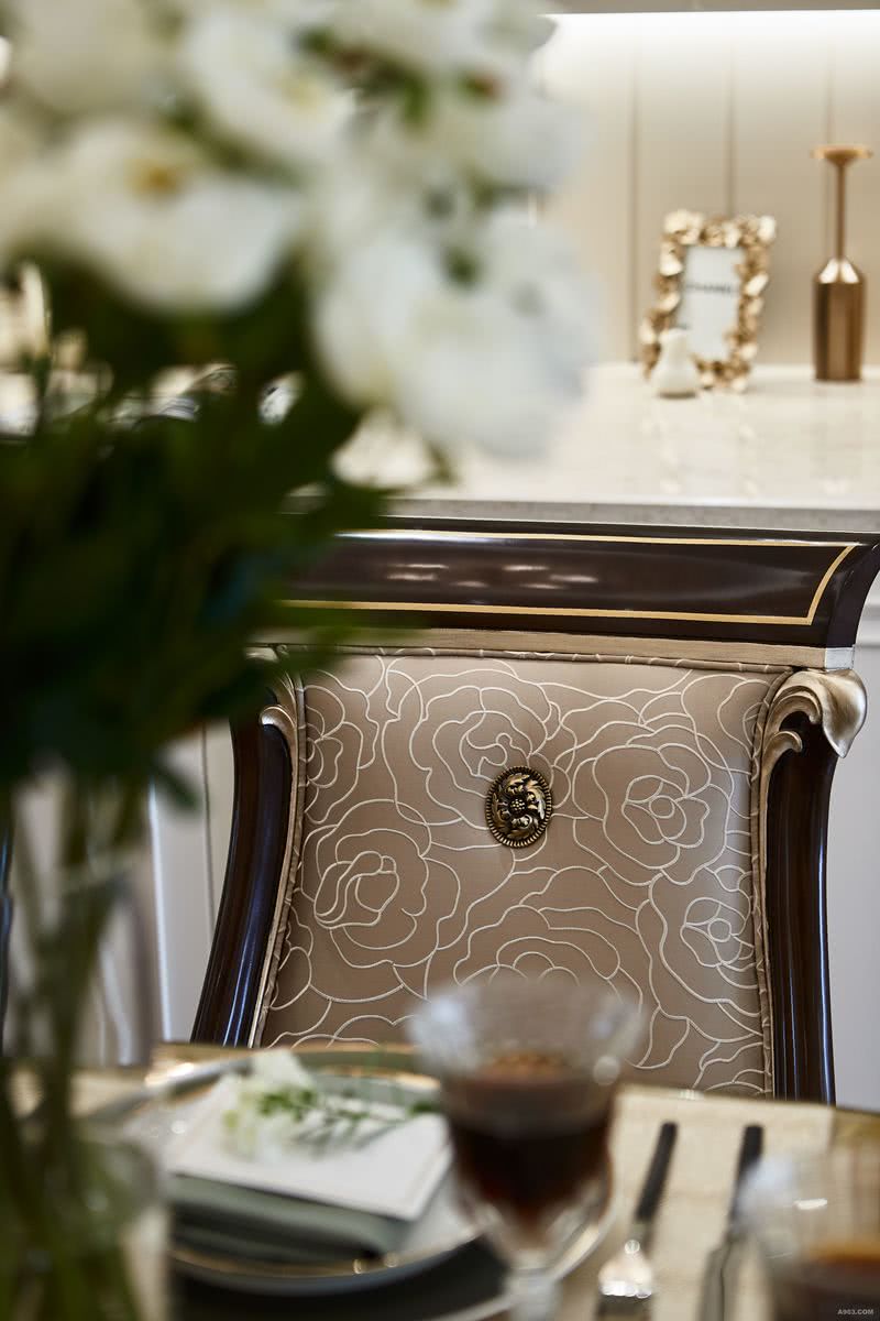 椅背的细条花纹，呼应餐厅装饰画元素。金色的软装点缀，为空间增添精致感。