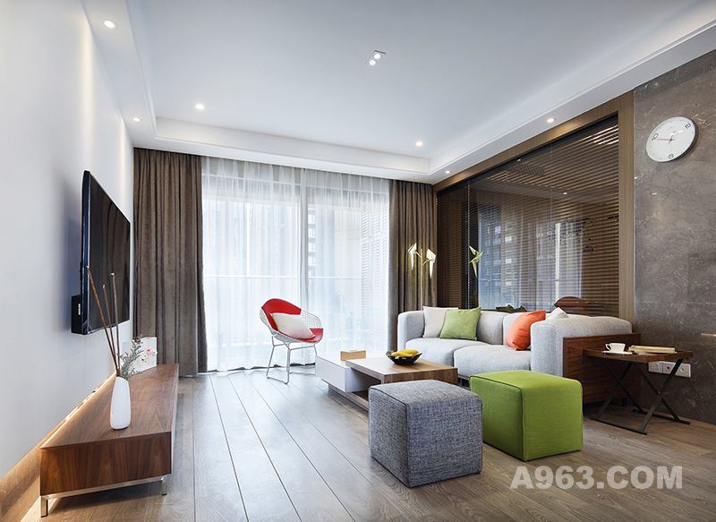 通过虚实互换的空间划分，来获得局部与整体的和谐。柔软的沙发及配饰，和整体硬线条的中和，给空间刚硬结合的跃动之感。通透玻璃形式设计的沙发背景墙，增强客厅空间的延展性。